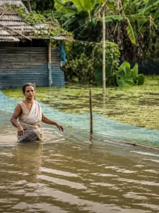Flooded Rural Shack with Wading Woman