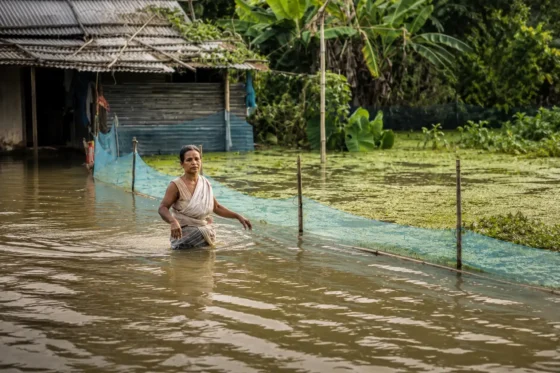 Flooded Rural Shack with Wading Woman