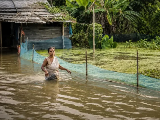 Flooded Rural Shack with Wading Woman