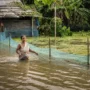 Flooded Rural Shack with Wading Woman